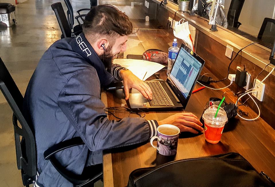 Man working on a laptop at a desk in a co-working space