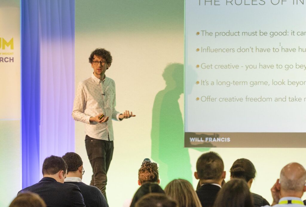 Speaker presenting on stage at the Quantum 2019 conference with an audience watching