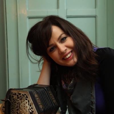 Portrait of a smiling woman with a concertina.